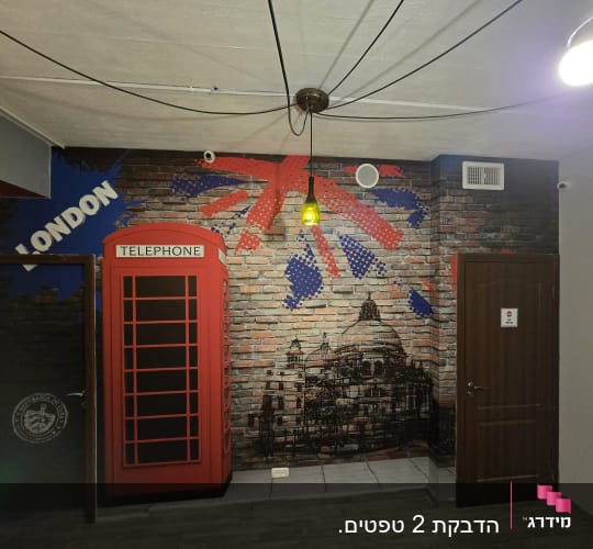 קיר עם ציור תא טלפון אדום ודגל בריטי